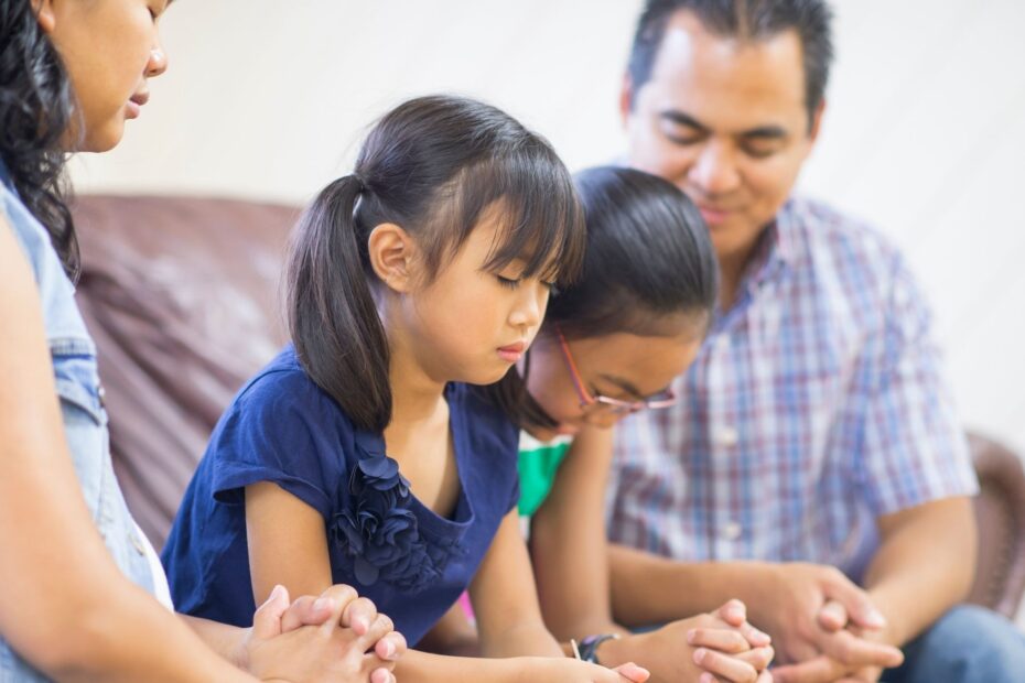 family praying together on the couch